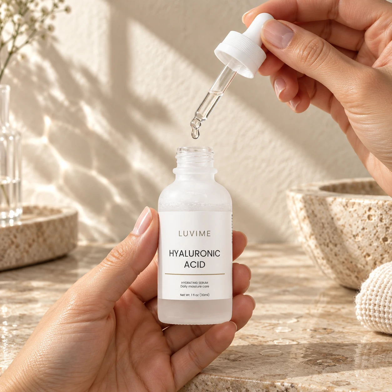 Luvime Hyaluronic Acid Serum held in hands with a dropper over a sunlit stone vanity