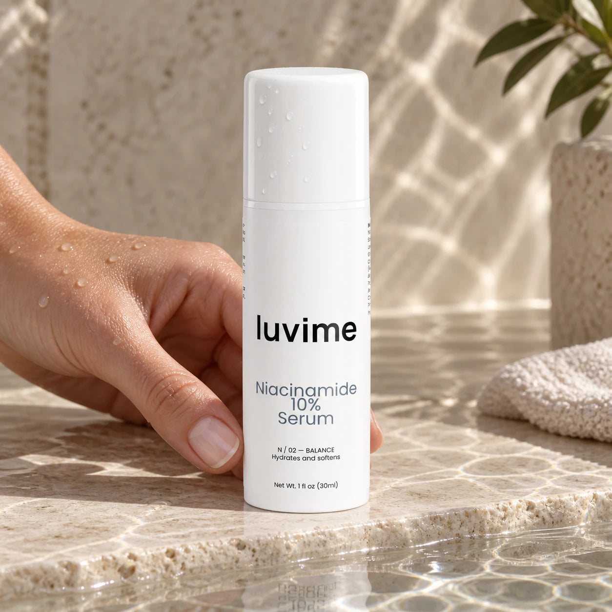 Luvime 10% Niacinamide Serum beside water reflections on pale stone